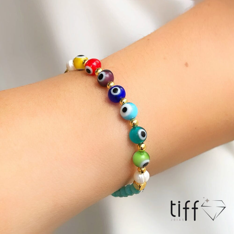 Pulseira em banho ouro 18k cristais azul claro com olho grego colorido e detalhe em bolinhas folheadas
